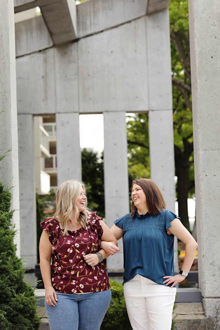 two women linking arms and laughing