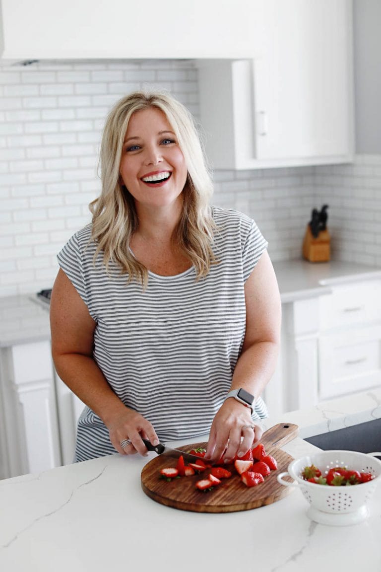 woman laughing while chopping strawberries