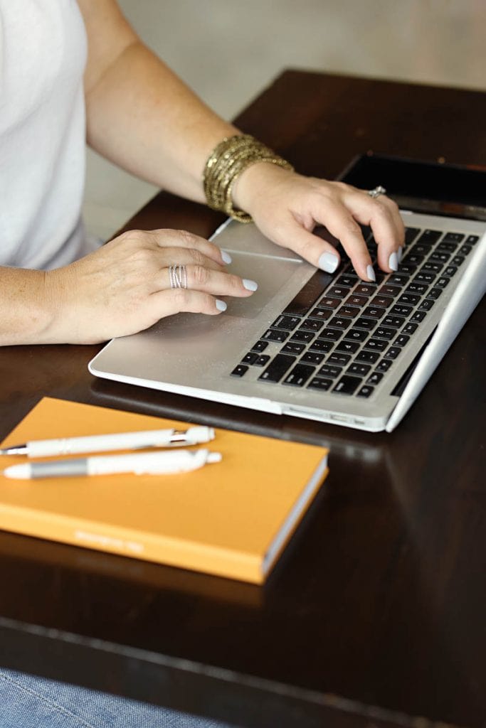 woman typing on laptop keyboard